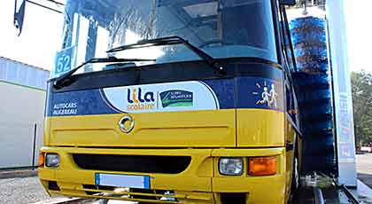 un portique de lavage bus nettoie un autocar jaune