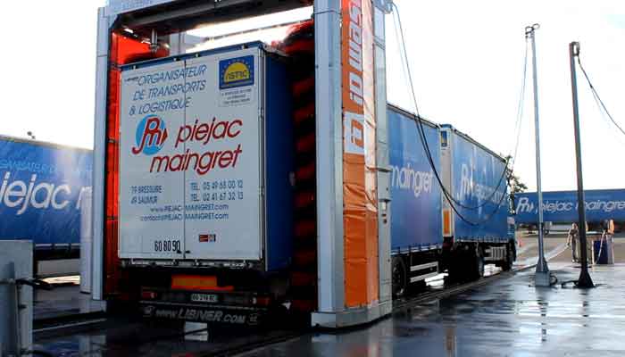 Station de lavage agroalimentaire en train d'effectuer un cycle de lavage sur un camion bleu